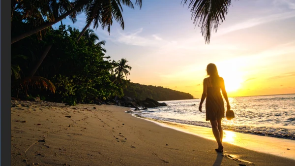 photo of woman walking on a sunset beach in illustrator