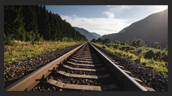 tilted photo of railroad track and mountainscape in photoshop